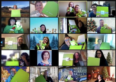 30 people smile and hold up green Cheeriodicals boxes on a Zoom call